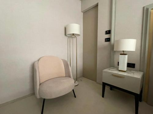 a room with a chair and a table with a lamp at Nordis 22 Deluxe Room Mamaia Nord in Mamaia Sat/Năvodari