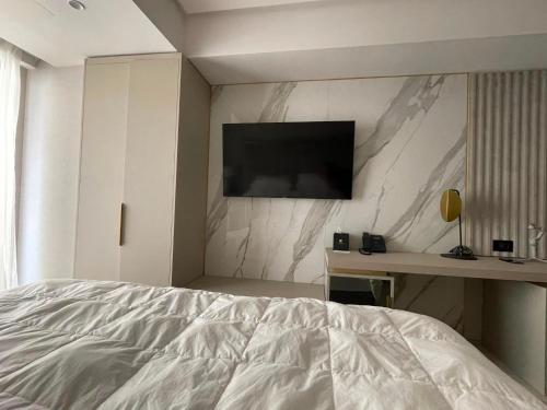 a bedroom with a bed and a television on a wall at Nordis 21 Deluxe Room Mamaia Nord in Mamaia Sat/Năvodari