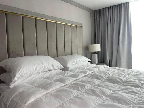 a large white bed in a hotel room at Nordis 20 Deluxe Room Mamaia Nord in Mamaia Sat/Năvodari