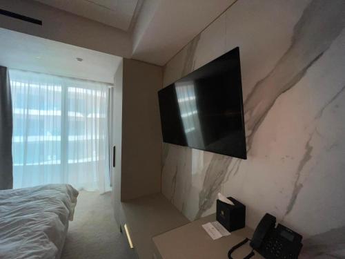 a bedroom with a flat screen tv on the wall at Nordis 20 Deluxe Room Mamaia Nord in Mamaia Sat/Năvodari