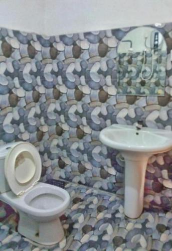 a bathroom with a toilet and a sink at Rithu Homestay in Sigiriya
