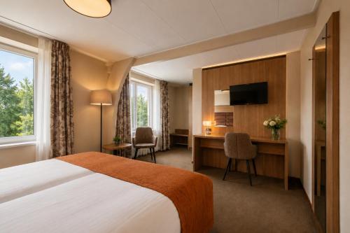a hotel room with a bed and a desk at Hotel de Landmarke Ootmarsum in Groot-Agelo