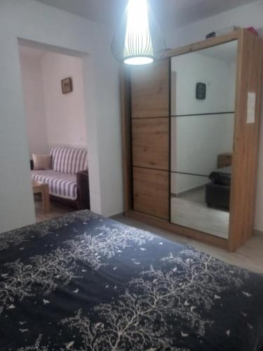 a bedroom with a large mirror and a couch at Asijaapartmani in Bar