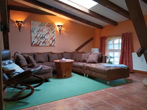 a living room with a couch and a table at Ferien am Schloss - Wohnung 6 "der Pferdestall", Ferienwohnung am Badesee in Behren-Lübchin