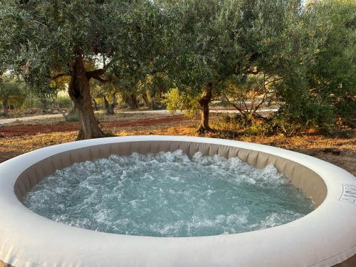 a hot tub in a garden with trees in the background at Riza Eco Tents in San Vito lo Capo