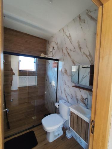 a bathroom with a toilet and a sink and a shower at Recanto da Nonô in Gonçalves