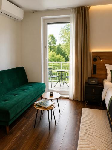 a living room with a green couch and a table at Boutique Hotel at Golf Piestany in Piešťany