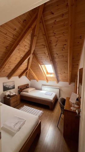 a bedroom with two beds and a desk in a attic at JOEN Village in Librazhd