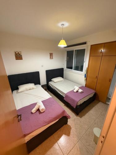 two beds in a room with towels on them at Lux Family Suite & Pool in Larnaca