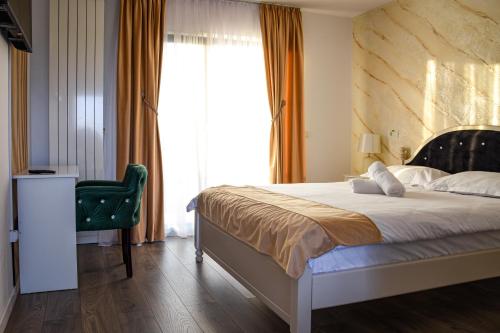 a bedroom with a bed and a large window at Cataleya House in Oeşti-Pămînteni