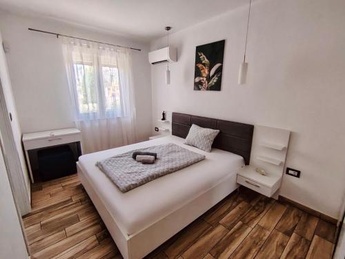 a bedroom with a large white bed and a window at Villa Alba in Vodnjan