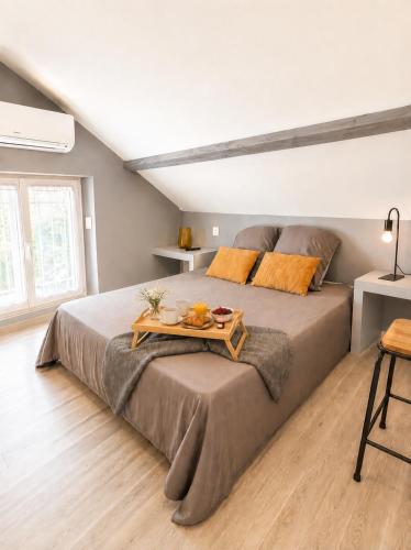 a bedroom with a bed with a tray of food on it at Petite maisonnette avec accés piscine in Montauban