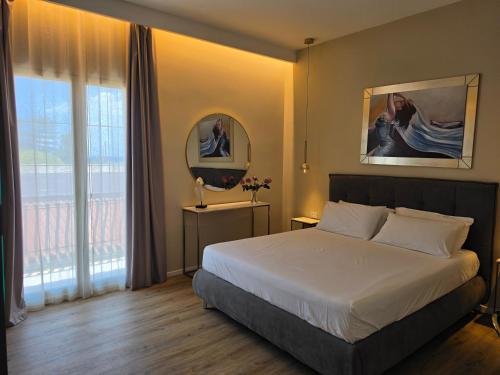 a bedroom with a bed and a large window at Villa Merilusi Apartments in Fontane Bianche