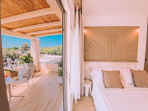 a bedroom with a white bed on a balcony at Lentischi Hotel - Adults Only in Villasimius