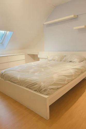 a large white bed in a room at Cozy duplex apartment with free parking in Leuven