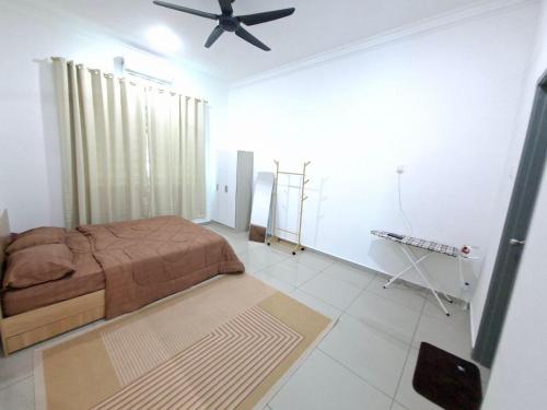 a bedroom with a bed and a ceiling fan at D'Biru Homestay Segamat in Segamat