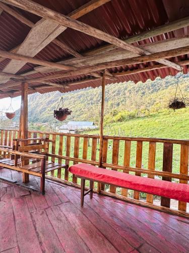 Eine rote Bank steht auf einer Holzterrasse mit Aussicht in der Unterkunft Monte Gocta in Valera