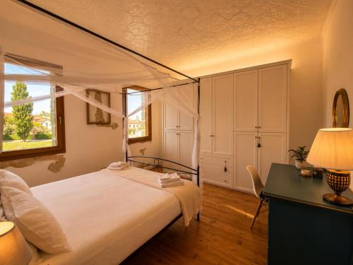 a bedroom with a bed and a desk and a window at Villa Venezia Apartment in Dolo