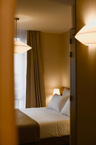 a hotel room with a bed and a window at Hotel Local 101 Beaurepaire in Paris