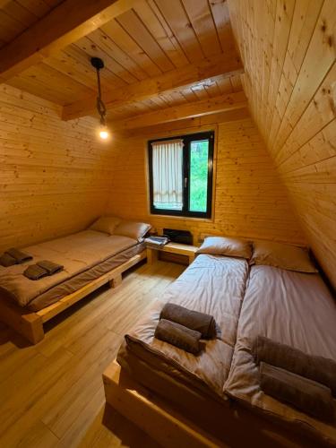 a room with two beds in a log cabin at Cabana La Poiata in Valea Chioarului