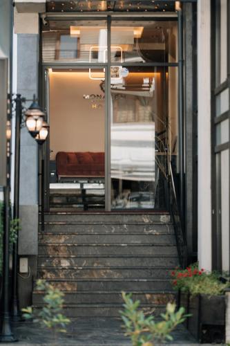 eine Treppe, die zu einem Gebäude mit einem Bett hinaufführt in der Unterkunft Monarch Boutique Hotel in Prizren