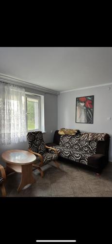 a living room with a couch and a table at Przytulna Kawalerka Łeba in Łeba