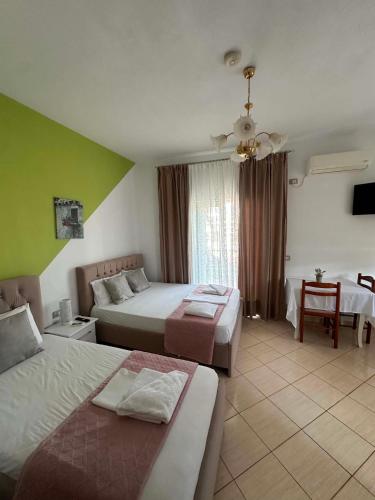 a hotel room with two beds and a table at Oliver Studios in Ksamil