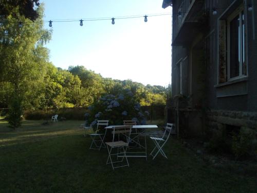 a table and chairs in the yard of a house at Villa Signerose - chambres chez l'habitant au cœur de l'Ardèche - Hautes vallées in Le Cheylard