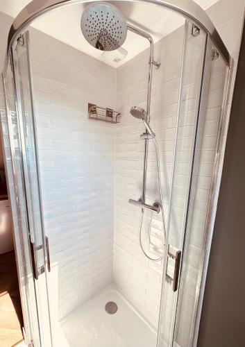 a shower with a glass enclosure in a bathroom at Au petit Cachou in Port-Bail-sur-Mer