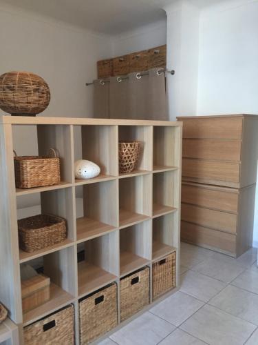a kitchen with wooden shelves and baskets at Appartement Canet in Canet-en-Roussillon
