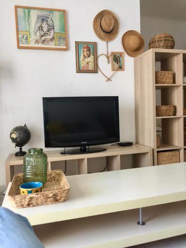a living room with a tv on a white table at Appartement Canet in Canet-en-Roussillon