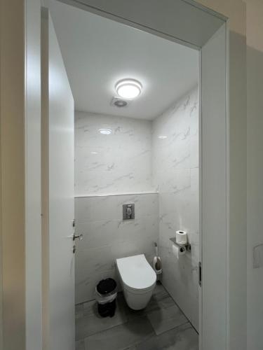 a bathroom with a white toilet in a room at סוויטת נוף התכלת in Migdal