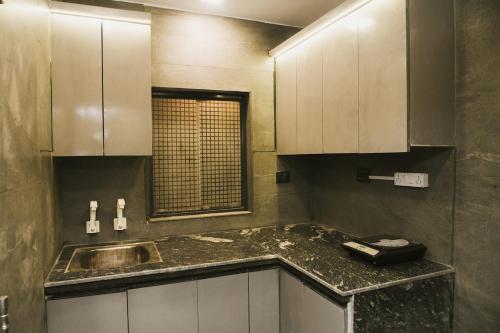 a kitchen with a sink and a counter top at Grey Courtyard Entire Studio Taj Mahal Parking 3KM in Agra