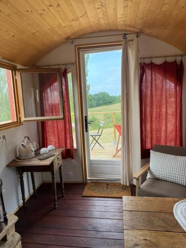 a room with a window and a table and a couch at Chambre Panoramique Bellevue in Bellegarde-Adoulins