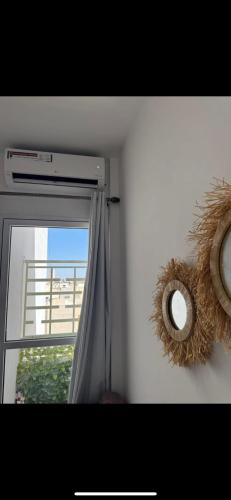 a window with a curtain and a mirror next to it at Fès comfort stay in Fez