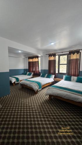 a row of beds in a room with windows at Hotel Marpha Comfort And Restaurant in Tukucha