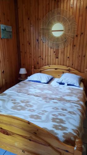 a bedroom with a wooden bed with a fan at Chalet Saint Julien en Born in Saint-Julien-en-Born