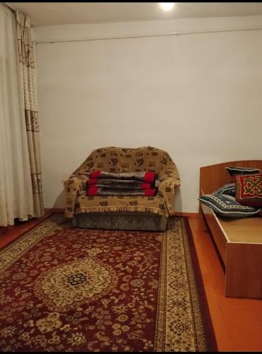 a living room with a couch and a rug at Keremet house in Barskoon