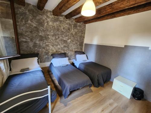 two beds in a room with wooden floors at venice private rooms in Venice