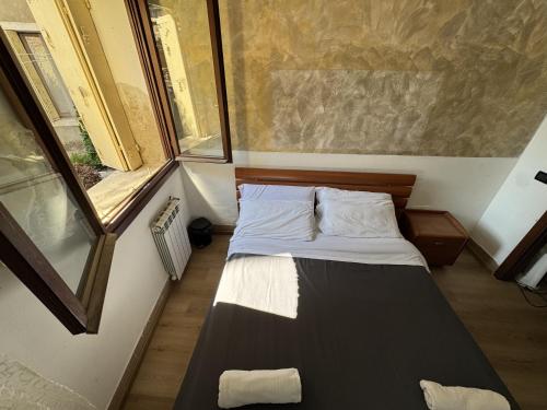 a small bed in a small room with a window at venice private rooms in Venice