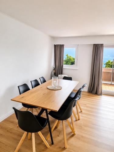 a dining room with a wooden table and chairs at Bright Lake-View Apartment in Montreux