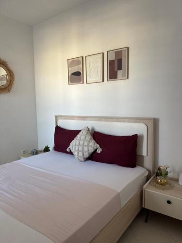 a bedroom with a white bed with red pillows at Fès comfort stay in Fez