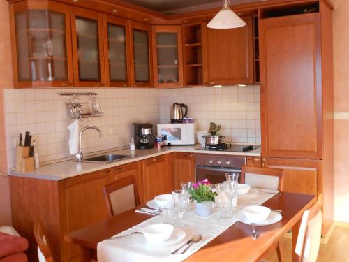 une cuisine avec des placards en bois et une table avec de la vaisselle dans l'établissement Апартамент Мур, à Sofia