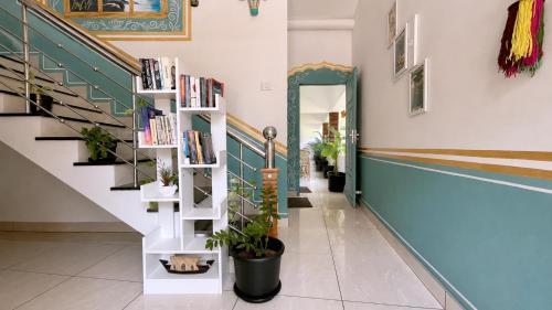 a hallway with a book shelf and stairs with books at Gypsy Walker in Varkala