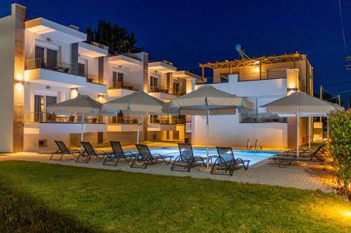 a group of chairs and umbrellas in front of a building at Porto Dionysos in Ofrínion