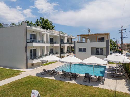a building with a swimming pool with umbrellas and chairs at Porto Dionysos in Ofrínion