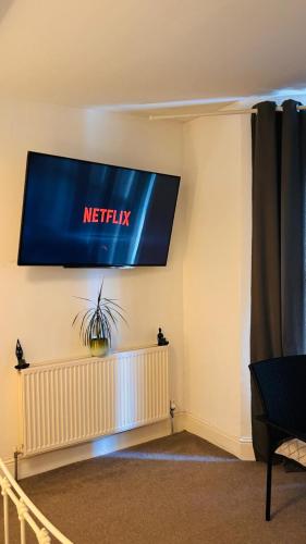 a television hanging on a wall in a room at Private Ensuite Room with Bay Window, Free Parking and Fast WiFi in Sheffield