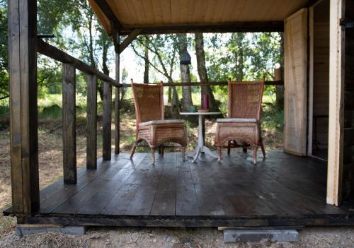 a porch with two chairs and a table on it at Cottage in Remízek in Havlíčkŭv Brod