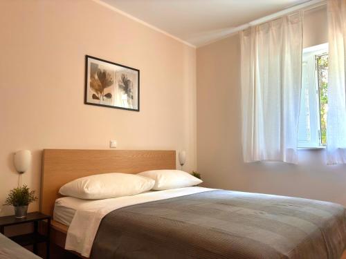 a bedroom with a bed and a window at Lenka Apartments I in Novalja