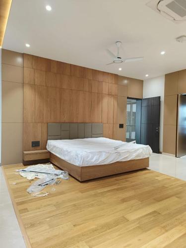 a bedroom with a large bed and a wooden wall at Vassu Bhavan in Bharwain